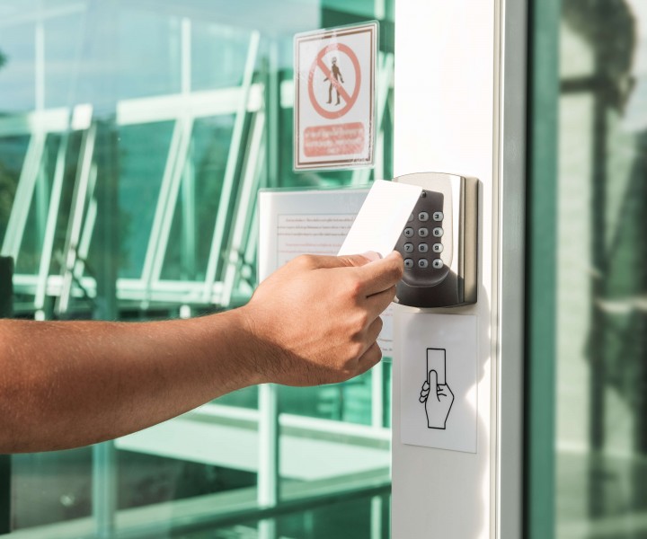 Hand using security key card scanning to open the door to entering private building. Home and building security system